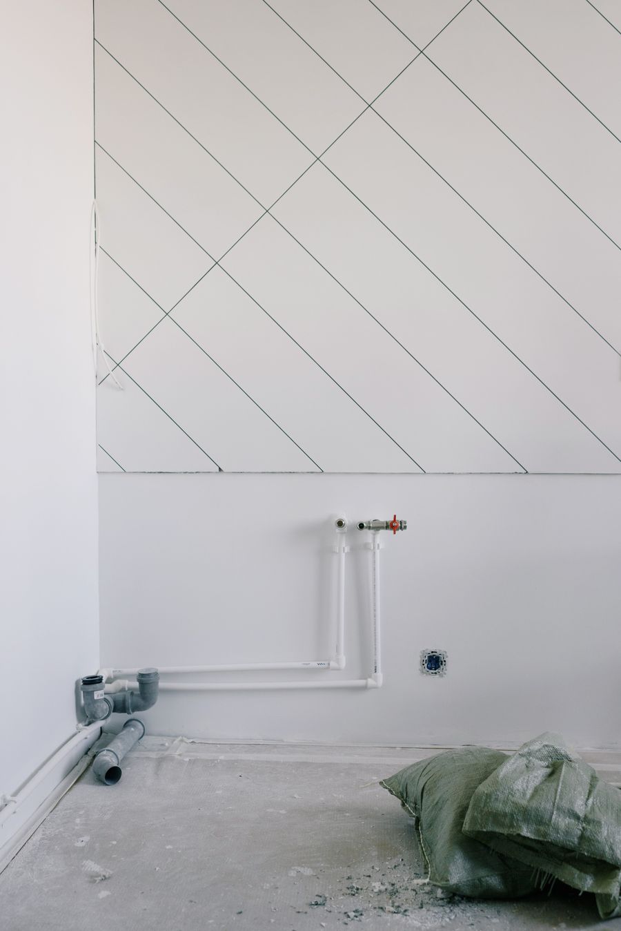 Capped copper pipe stubs projecting from a plain white wall